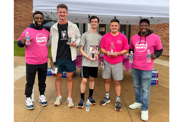 Gerald Douglas '18 (far left)  stand with a group of students and coworkers at the annual Breast Cancer Walk on campus this past fall.
