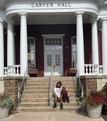 Felicia Ellzy sits on the steps of Carver Hall with her son, Jamie.