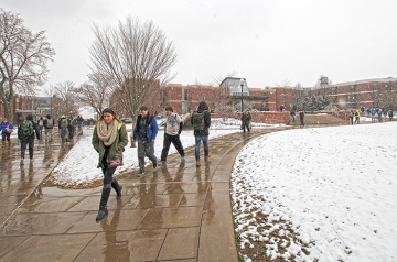student walking to class while it is snowing