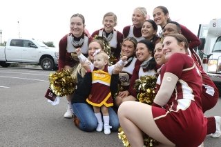 Cheerleaders with Child at Homecoming