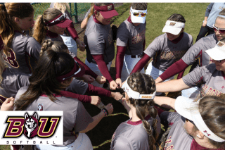 Photo of softball players in a huddle with the BU Softball logo in lower left corner