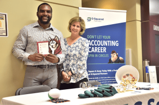 Two members of the HR staff of G-Squared Partners stand behind a table at recent Career Connections Expo