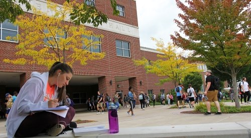 Anthropology major finishes her homework in front of Centennial Hall in the fall