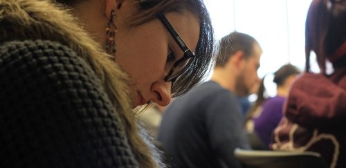 Economics major takes notes during a class lecture in Sutliff Hall