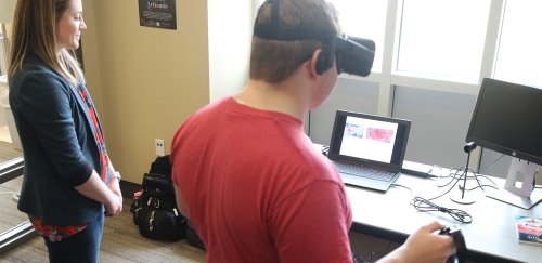 Instructional Technology students with a Virtual Reality (VR) headset.