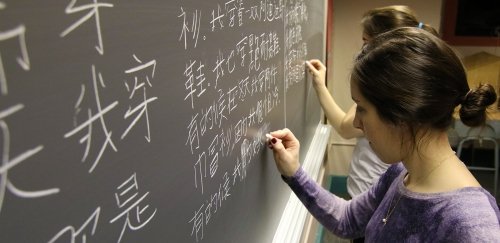 Chinese majors write their lesson out on a blackboard during class