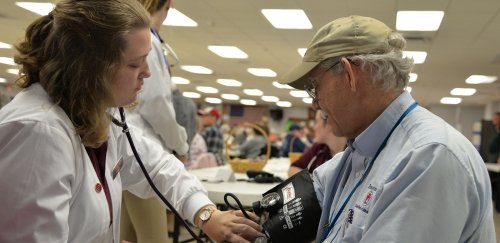 A graduate nursing student takes a patient's blood pressure.