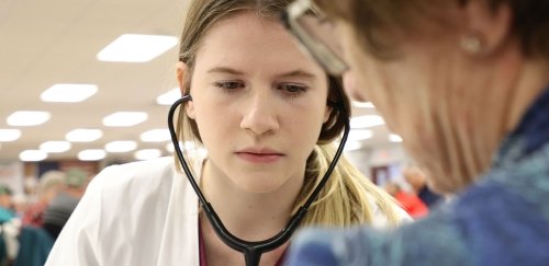 A graduate nursing student takes a patient's blood pressure.