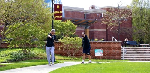 Students walk past the Student Services Center during an April afternoon