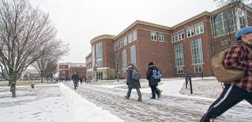 Students walking to class across snow covered sidewalks on campus