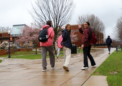 Friends say goodbye as they walk from the Quad in spring