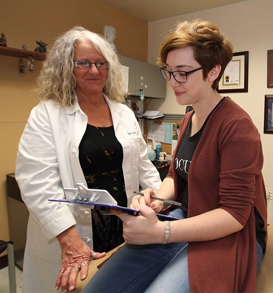 A member of the medical staff at the Student Health Center talks with a student patient.