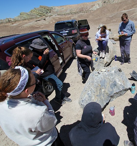 Geology professor leads a discussion for a rock lesson out in the field in the desert of California