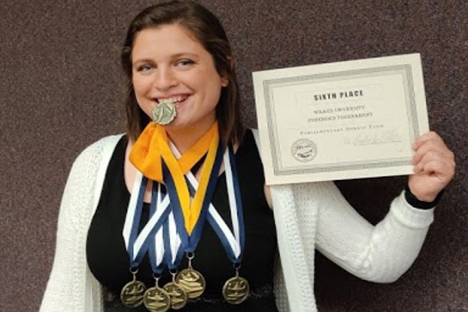 Forensics student shows off her speech and debate awards