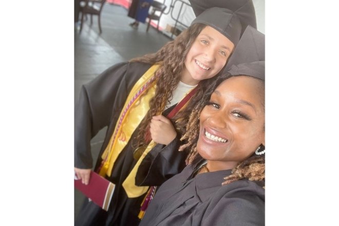 Outgoing alumni board president,Felicia Ellzy takes a selfie with the senior class president at the 2022 commencement.
