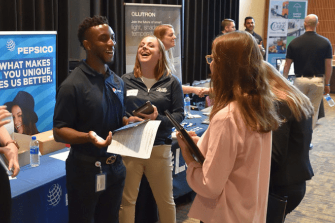 Gerald Douglas '18 speaks with a student as a recruiter for PepsiCo